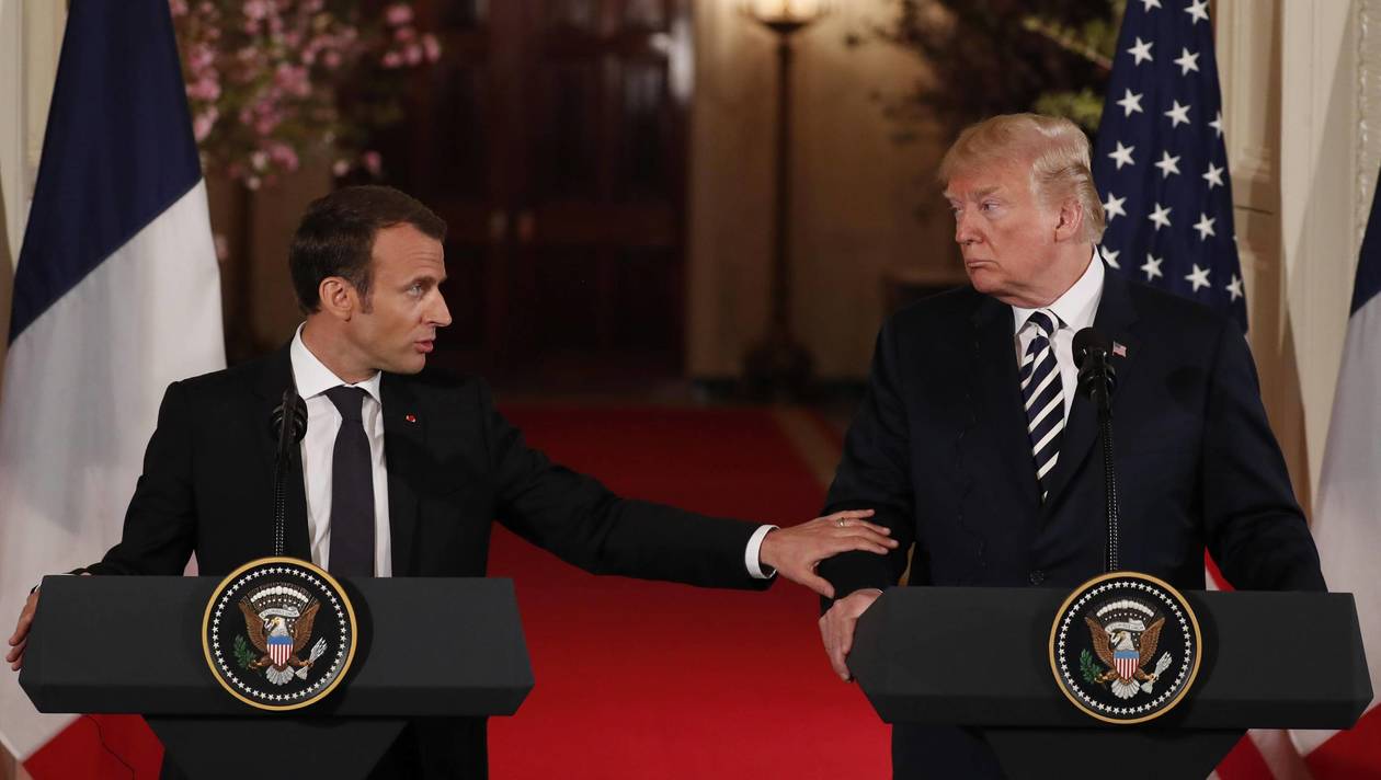 French President Macron reaches out to U.S. President Trump during their joint news conference at the White House in Washington